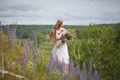 Medieval lady in historical dress. Aroma of spring nature, wild flowers, blue sky, sunshine.