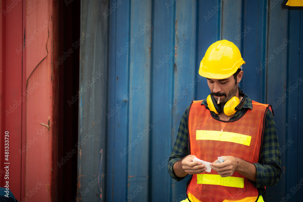 foreman worker person smoking cigarette tobacco at container yard outdoor work