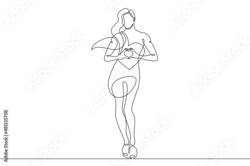 One continuous line.Beautiful woman holding a heart in her hands.Valentine's Day. Girl with a heart symbol of love. Continuous line drawing.Lineart isolated white background. © derplan13