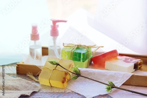 Handmade soap, spray, aromatic oil and healthy tinctures on a wooden table, the concept of cleanliness, hygiene, health, body care, gift wrapping