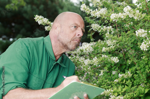 mature and concentrated gardener holding clipboard
