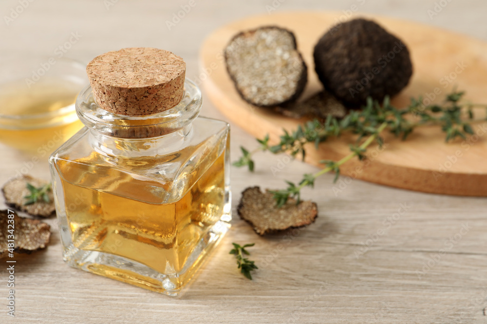 Fresh truffle oil and thyme on wooden table, closeup. Space for text Fresh truffle oil and thyme on wooden table, closeup. Space for text