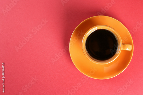 Coffee in cup on red background, top view. Space for text