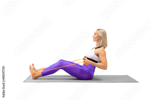 Resistance band seated back rows exercise. Attractive athletic woman sitting on a mat and work out using fitness props, isolated on white.