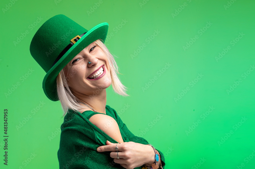 St. Patrick's Day. Beautiful smiling woman wearing green hat. Green background St. Patrick's Day. Beautiful smiling woman wearing green hat. Green background
