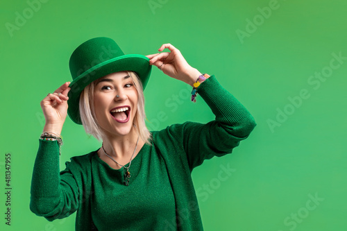 St. Patrick's Day. Beautiful smiling woman wearing green hat. Green background photo