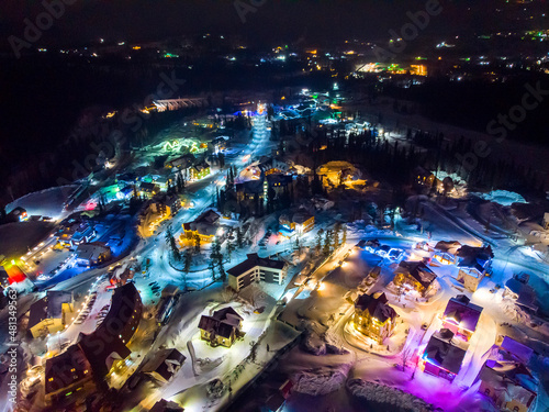 Sheregesh Kemerovo region ski resort in winter, night landscape on mountain and hotels, aerial view