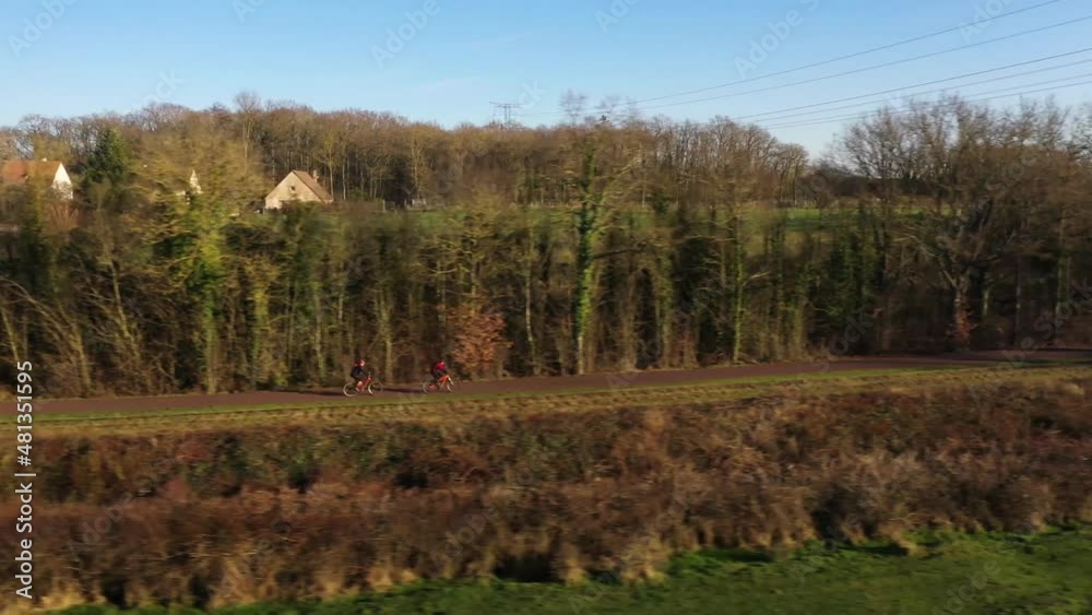 two men bicycling ion the greenway of Normandy in France two men bicycling ion the greenway of Normandy in France