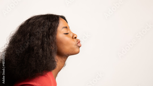 Photography Profile Shot Of Young Black Woman Pouting Lips Over White Studio Background