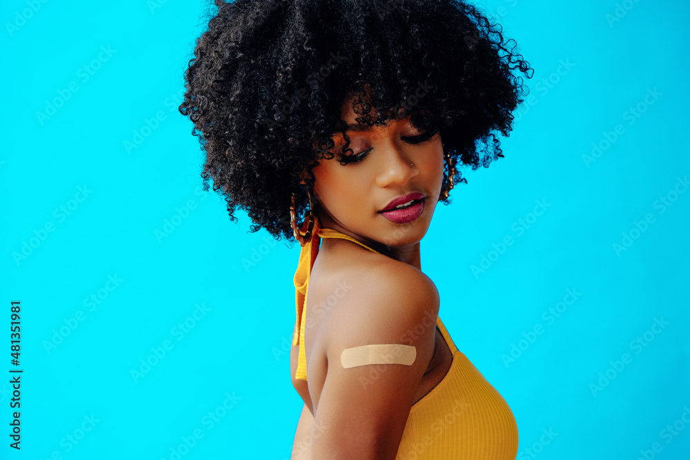 close up beautiful young woman with curly hair and bandaid on arm posing in studio - obrazy, fototapety, plakaty 