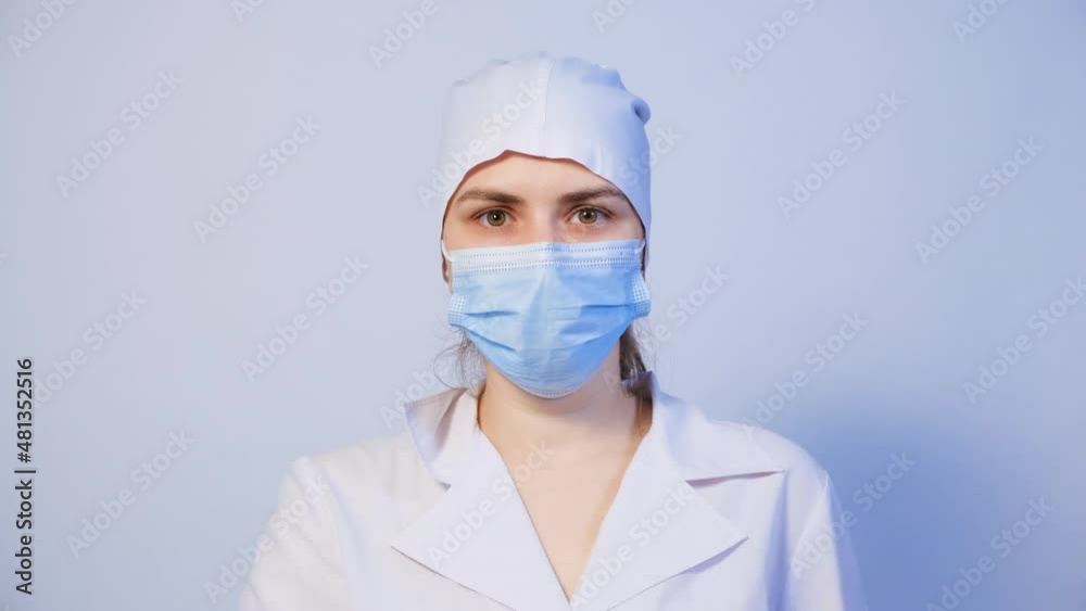 A doctor in a medical mask holds a finger in front of his mouth, a gesture of silence or secretion. A doctor in a medical mask holds a finger in front of his mouth, a gesture of silence or secretion.