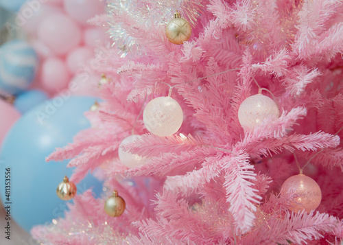 Pink Christmas tree decorated with gold and white balls. Unusual decoration for Christmas. Stylish decorations, background with Christmas theme