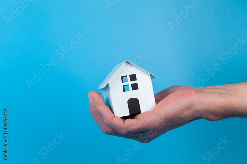   Hand with a toy house.