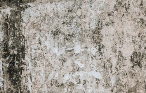 A weathered and damaged painted wall background. A dirty old plaster wall texture.