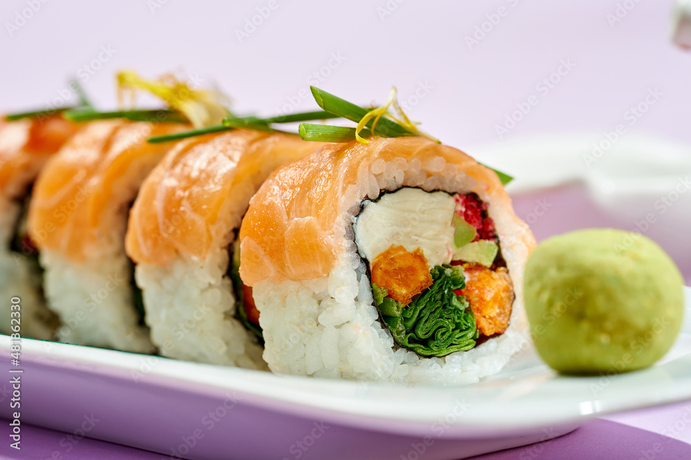 Sushi roll with salmon, cream cheese, onion and sweet potato. Bright backgrounds. Hard shadows, selective focus. Sushi roll with salmon, cream cheese, onion and sweet potato. Bright backgrounds. Hard shadows, selective focus.