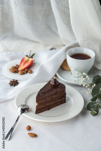 Slice of Triple Chocolate Ganache Cake and cup of tea on the table