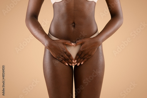 Unrecognizable black woman holding palms over panties