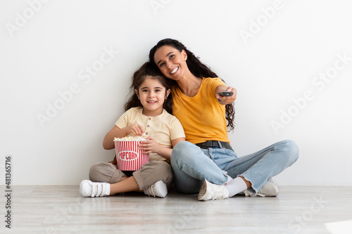 Mother Daughter Leisure. Happy Young Woman And Female Child Watching Tv Together