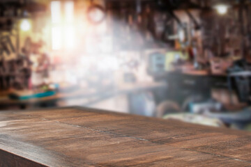 A wooden table with a vacant space and the interior of a repair shop in the background 