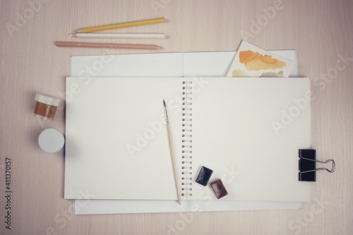 A set of art materials, a notebook on rings, pencils, paints, a desktop