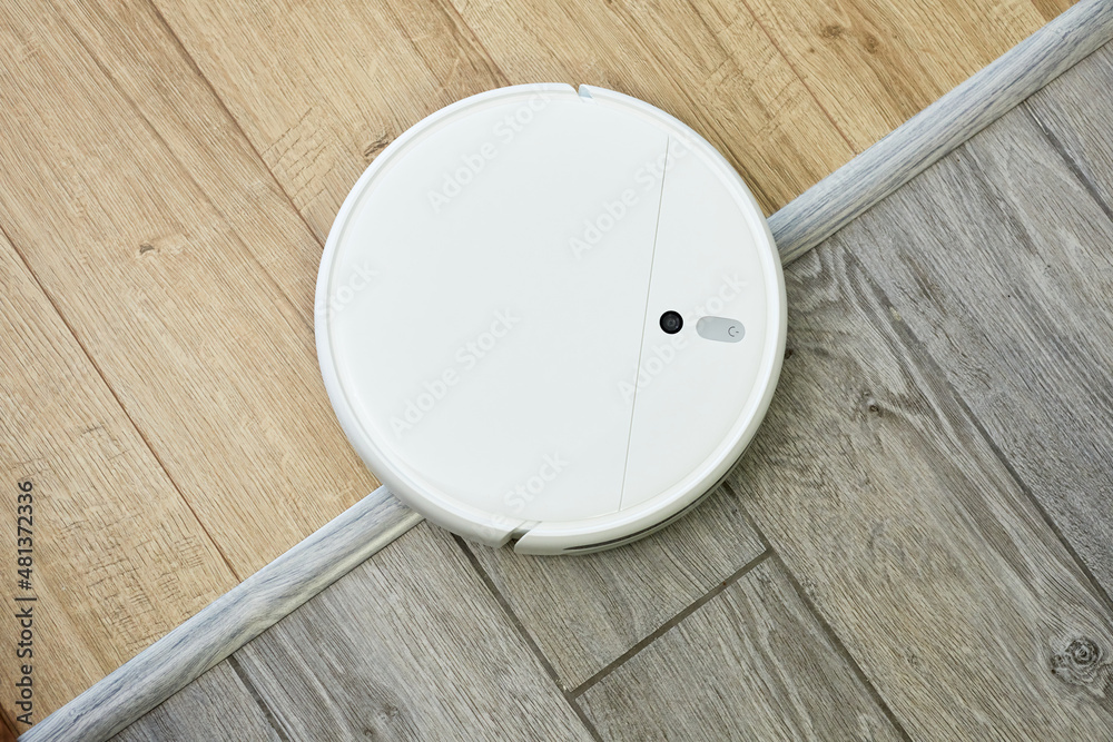 Robot vacuum cleaner drives on different surface. Overcoming doorstep with robot  vacuum cleaner. Concept modern wireless appliances. Stock Photo | Adobe  Stock