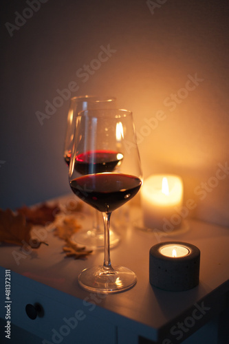 Candlelight date - two glasses of red wine with candles on the table. Romantic night with wine