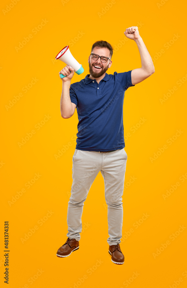 Positive man shouting in megaphone in studio Positive man shouting in megaphone in studio
