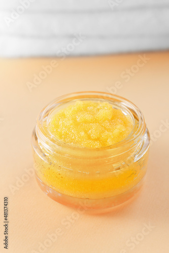 Homemade orange sugar scrub on the table close-up. Cleansing cosmetic product for beauty treatments and spas.