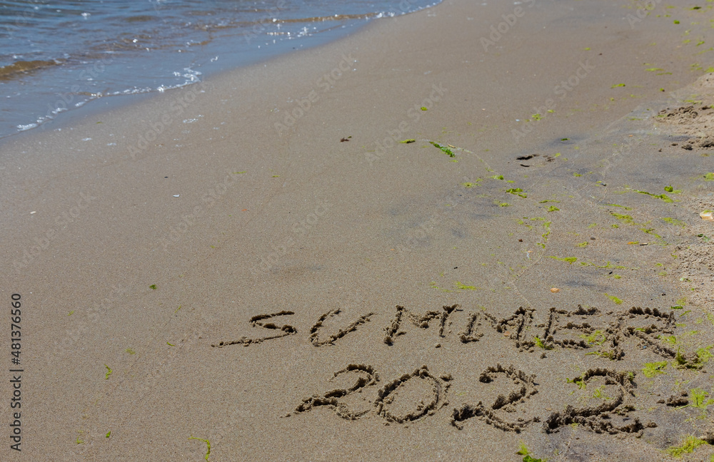 Fototapeta premium The inscription on the sand Summer symbolizes a summer 2022 vacation at the sea