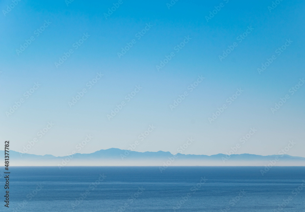 a landscape background wallpaper image looking out over the Mediterranean Sea at the mountainous coast of northern Africa 