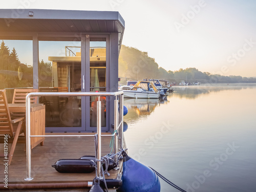 houseboat on a river in a early sunny morning. floating house is a pleasant place for rent for weekend photo
