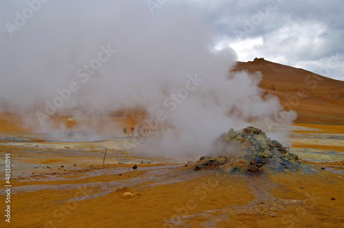 Supernatural landscape at geothermal field Mars like site Hverir Namafjall wasteland with pools of boiling mud, mudpots, hot springs, hissing chimneys of fumaroles and orange and red colors photo