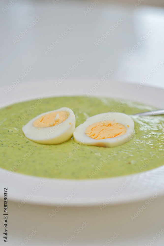 Vegetarian diet and vegan food, green healthy broccoli soup on a plate on a clean kitchen table. Tasty and nutritious meal, lunch or dinner Vegetarian diet and vegan food, green healthy broccoli soup on a plate on a clean kitchen table. Tasty and nutritious meal, lunch or dinner