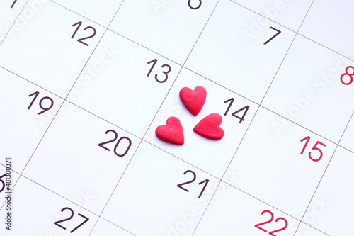 Valentine's day red hearts on calendar with 14 february date background, love, celebration concept 