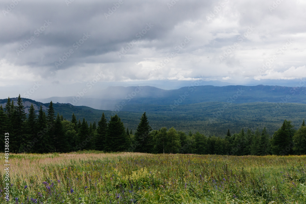 View on a rain clouds over mountain forest valley in Russia