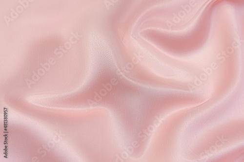 Close-up texture of natural red or pink fabric or cloth in same color. Fabric texture of natural cotton, silk or wool, or linen textile material. Red canvas background.