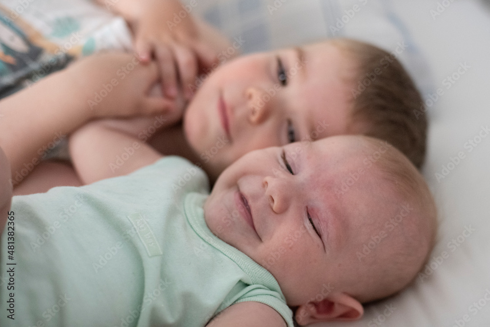 Niños bebés hermanos jugando en la cama de sus padres abrazados Niños bebés hermanos jugando en la cama de sus padres abrazados