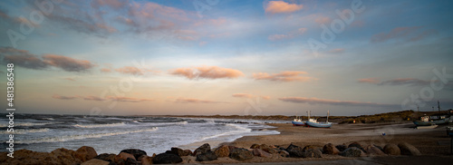 Beach of norre vorupor, denmark, sunset over old fishing boats