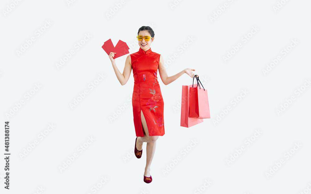 Beautiful cheerful Asian woman wearing red costume, smiling, holding angpao, shopping bag on white background with copy space, present sale promotion advertisement, celebrate Chinese New Year. Beautiful cheerful Asian woman wearing red costume, smiling, holding angpao, shopping bag on white background with copy space, present sale promotion advertisement, celebrate Chinese New Year.