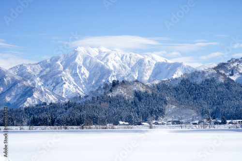 雪で覆われた真白な巻機山と手前に広がる白い野原