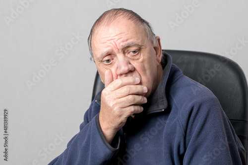 portrait homme âgée dépressif sur fond gris