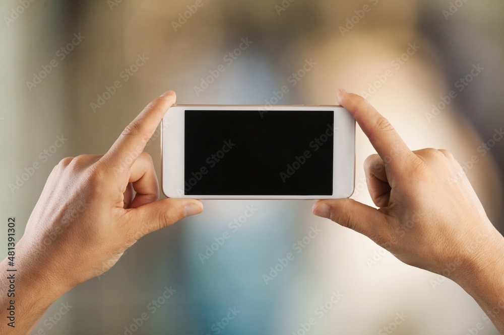 Hands hold smartphone with blank screen
