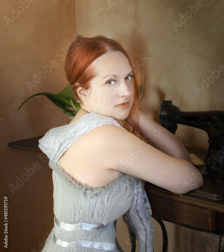 Fashion portrait of a red hair girl wirh an elegant dress and lace shawl photo