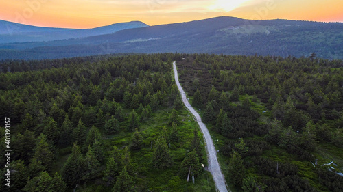 Aerial shot of road in forest. Drone shot of a road in the mountains.  photo