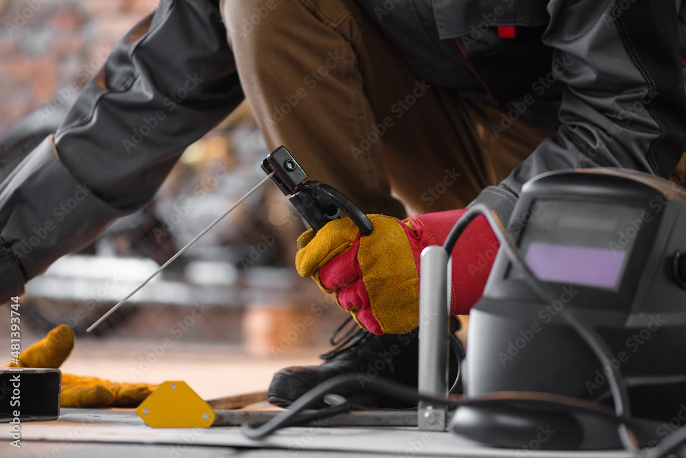 A welder is welding a metal frame close up.