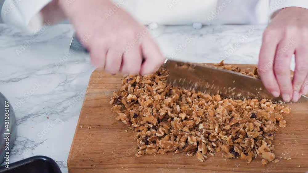 Step by step. Chopping walnuts with kitchen knife on a wood cutting board. Step by step. Chopping walnuts with kitchen knife on a wood cutting board.
