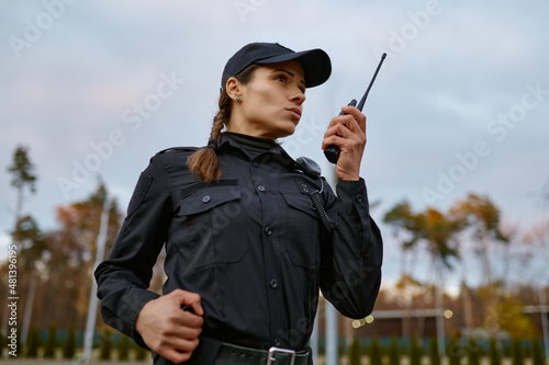 Fotografiet Patrol service police woman talking into walkie-talkie