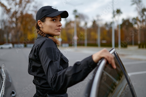 Bild auf Leinwand Police woman in uniform near car portrait
