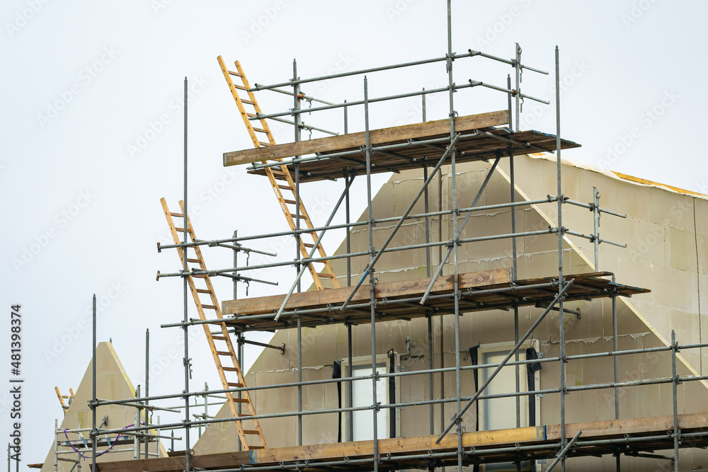 Houses under construction with scaffolding and ladders