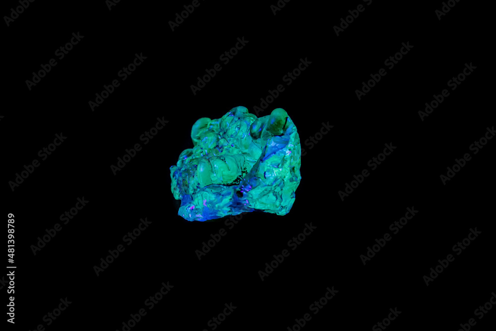 macro mineral stone opal under ultraviolet light on a black background
